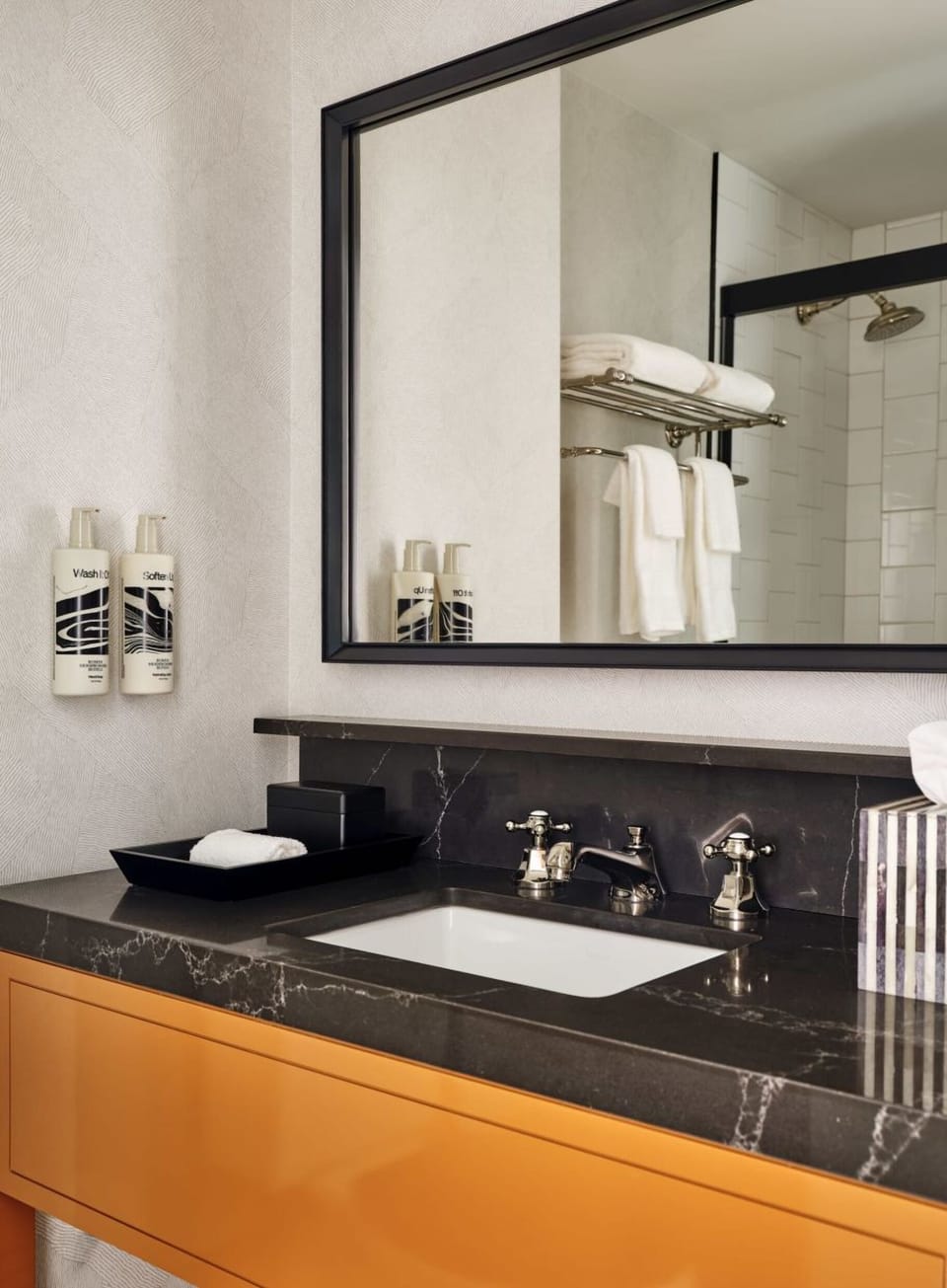 Refresh at a polished vanity with premium towels and bright lighting.
