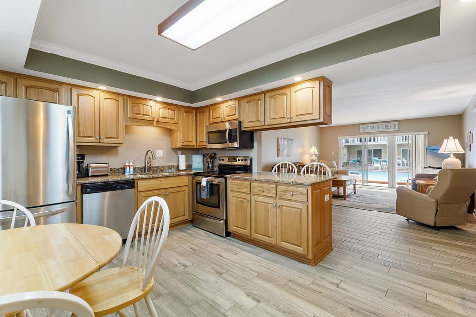 Cook with ease in this beachside kitchen and unwind in the open living area with pool views. A perfect setup for relaxing after a fun-filled day at the beach.