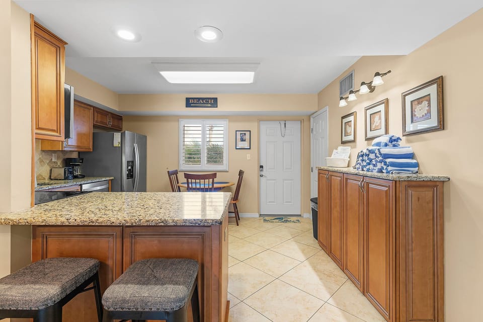 A welcoming beach stay entry with a cozy dining nook and fully stocked kitchen, perfect for grabbing snacks or meals before heading out for more coastal fun.