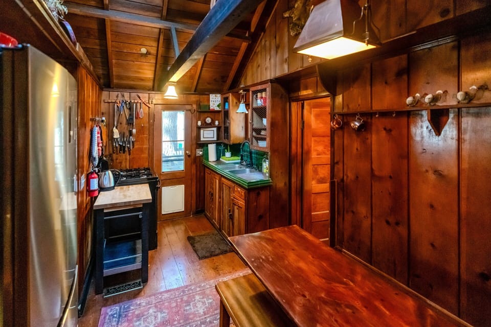 Interior hallway connecting the kitchen and living spaces, highlighting the home's unique cabin craftsmanship and functional layout.