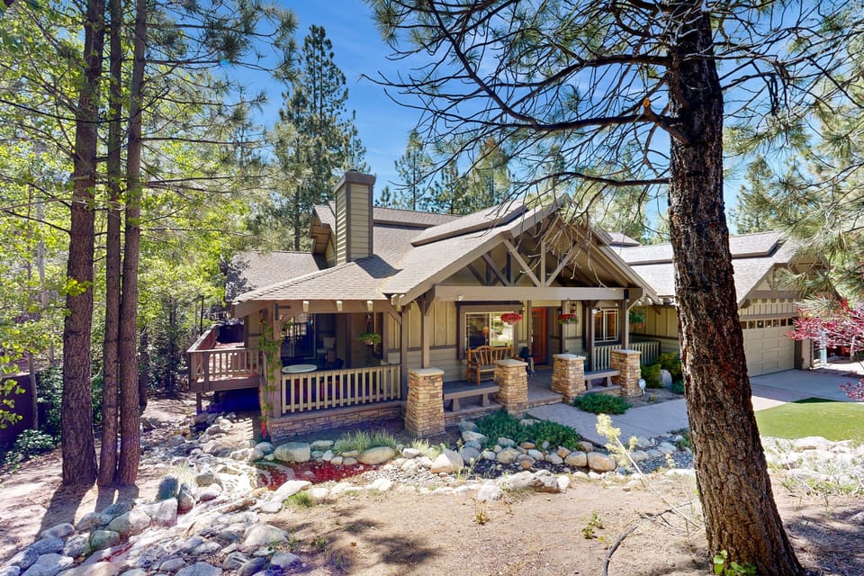 Welcoming cabin entry surrounded by towering pine trees, offering fresh mountain air and a peaceful forest setting—the perfect first impression for your Big Bear Lake getaway.