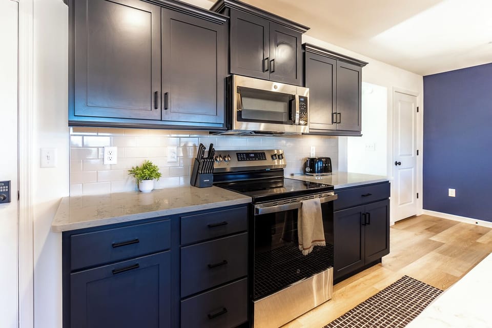 This spacious kitchen has everything you need, including a large size fridge, microwave, oven, four-burner range, oversized deep basin sink, coffee bar, blender, air fryer/toaster, and more!
