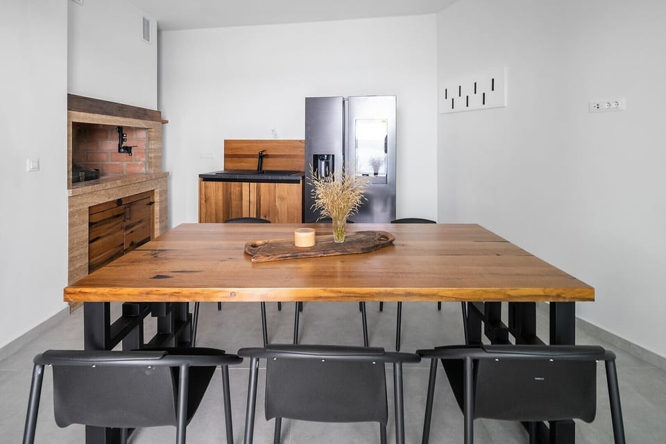  This area is equipped with a wood/charcoal barbecue, a refrigerator, an ice maker, and a sink