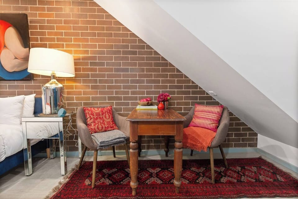 The intimate two-seater table sits on a bold patterned rug, offering a warm spot for casual bites or a quick breakfast.