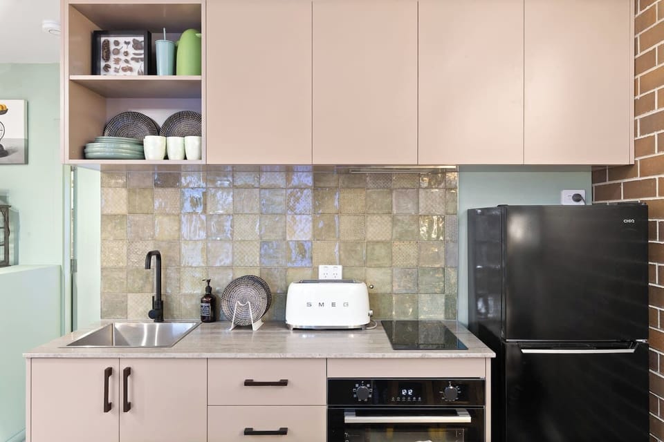 The kitchenette features a SMEG toaster, fridge, oven, and stove, plus a French press for your morning brew—all tucked into a compact design made for easy stays.