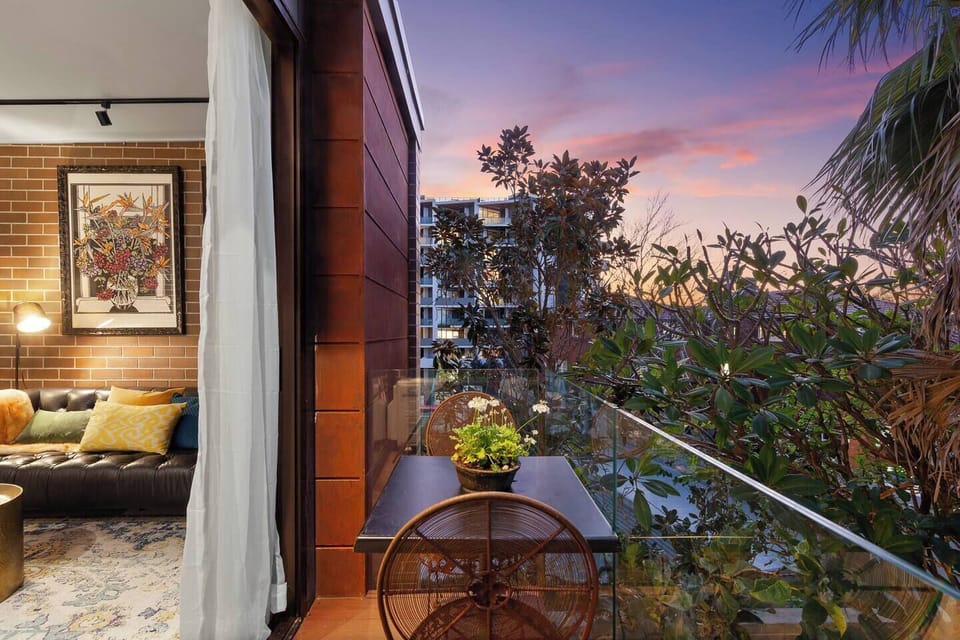 Step out to your private balcony—a small, leafy retreat with outdoor seating for two, perfect for quiet coffee moments or evening air.