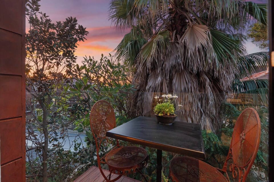 Step out to your private balcony—a small, leafy retreat with outdoor seating for two, perfect for quiet coffee moments or evening air.
