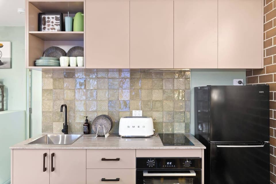 the first kitchenette features a SMEG toaster, fridge, oven, and stove, plus a French press for your morning brew—all tucked into a compact design made for easy stays.
