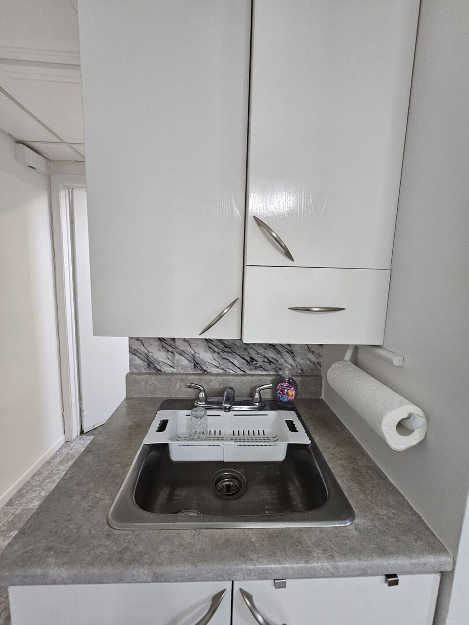 Functional kitchen corner with cabinets, sink, and essentials