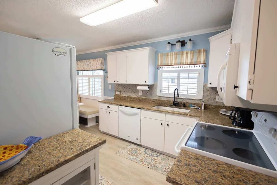 Cook up coastal meals in this modern kitchen featuring ample storage, updated appliances, and a seamless flow into the dining and living areas.