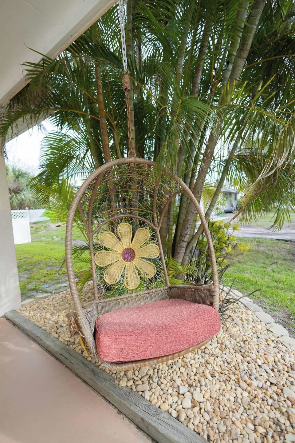 Welcome to your island getaway—colorful exterior, lush landscaping, and a front swing that invites you to slow down and relax.

