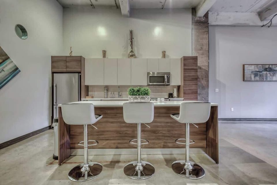 Whip up culinary delights in this modern kitchen, featuring sleek finishes and ample natural light!