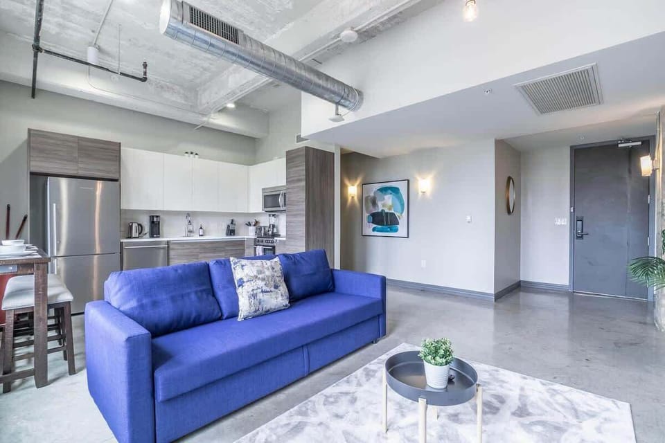Modern vibes with a vibrant blue couch and stylish decor - perfect for unwinding!