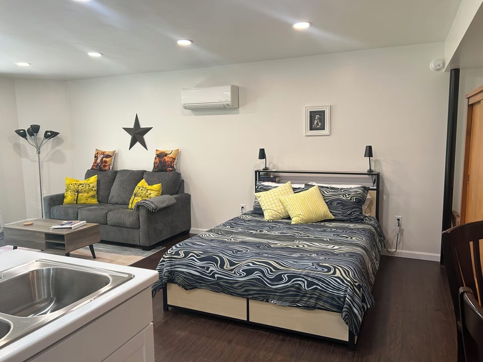 Main Space with queen bed, full sofa bed, coffee table. Top raises up for desk.