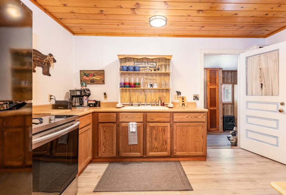 Open concept kitchen with full refrigerator and stove. 