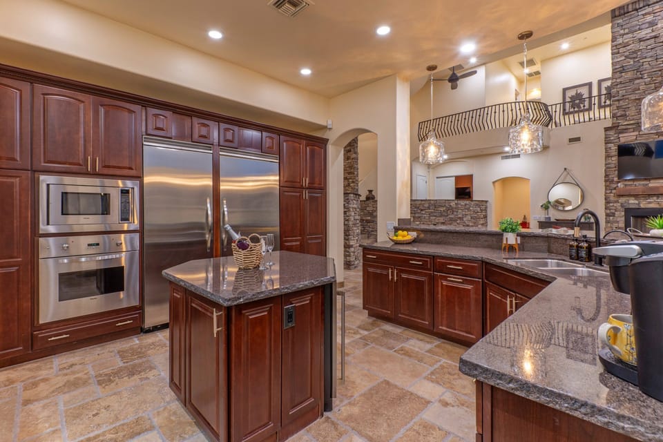 State of the art, completely stocked kitchen features 2 refrigerators and an island with a mini wine fridge.