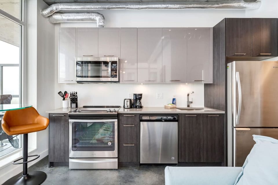 Cook like home in the fully equipped kitchen with a bar table and stools.