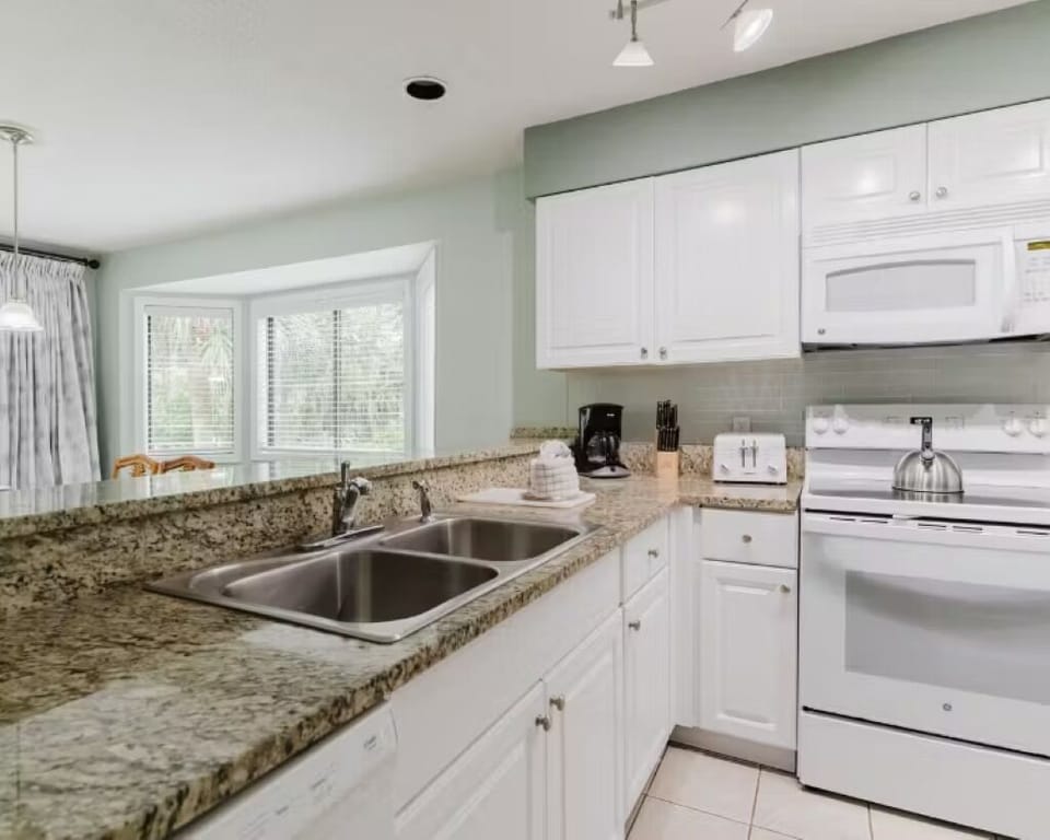 Cook effortlessly on spacious granite counters in a bright kitchen.