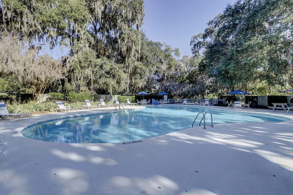 Dive into sunlit pool days beneath moss-draped oaks.