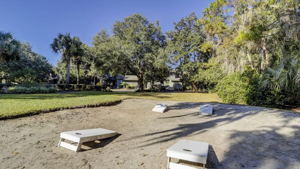 Challenge friends to cornhole on a sunny, open lawn.