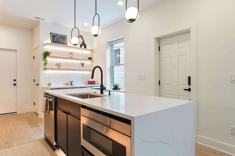 Huge island with dishwasher and microwave built into cabinets. Large stainless steel sink in the middle.