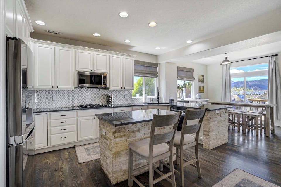 Cook, gather, and connect in this chef-ready space with dual prep islands, a gas cooktop, sleek tile backsplash, and plenty of natural light.


