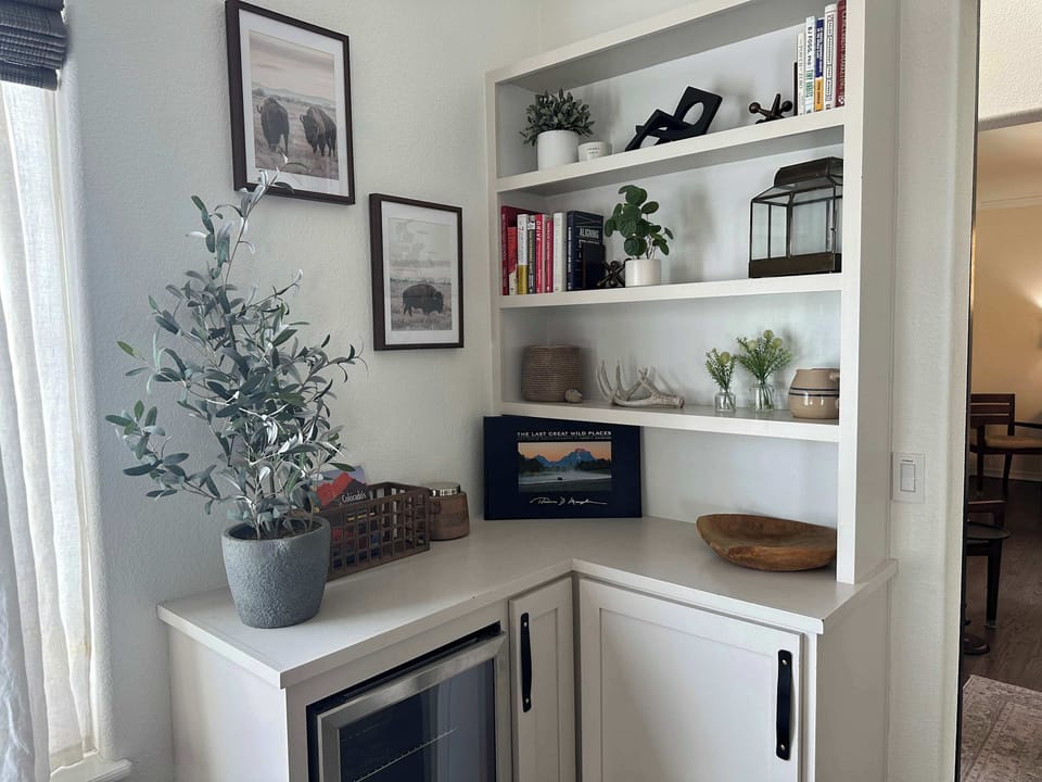 Charming built-in corner with a mini fridge, curated decor, and thoughtful extras—ideal for a glass of wine or morning pick-me-up.

