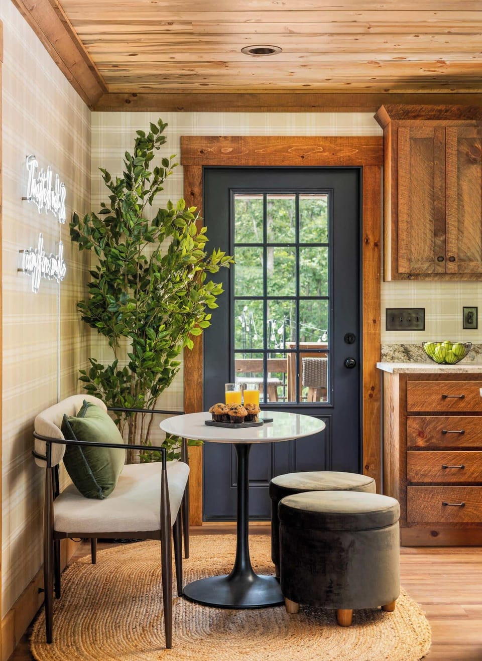 Just off the kitchen, this charming dining extension features a comfy nook and glowing neon that reads “Twisted Oak & Campfire Smoke”—a perfect spot to gather, sip, or snap a photo.