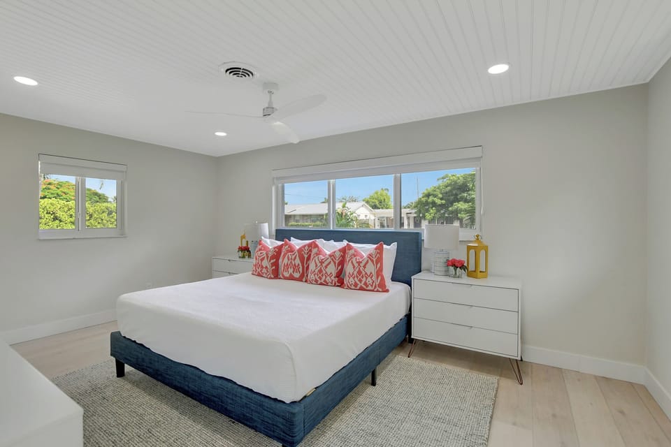 A second angle of this bedroom highlights the comfortable bed, warm accents, ceiling fan, and calm place to recharge.