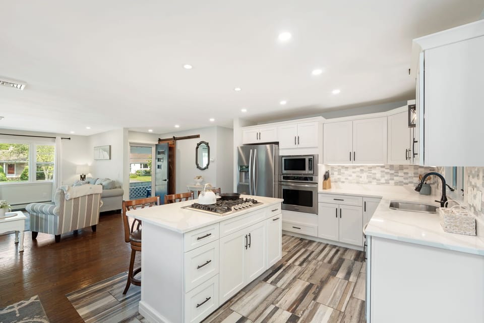 crisp white modern cabinetry, cook top, and stainless steel appliances 