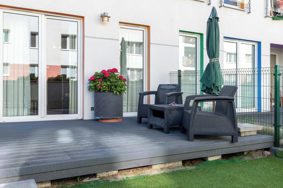A terrace area featuring lounge seating, umbrellas, and potted flowers, perfect for outdoor relaxation.