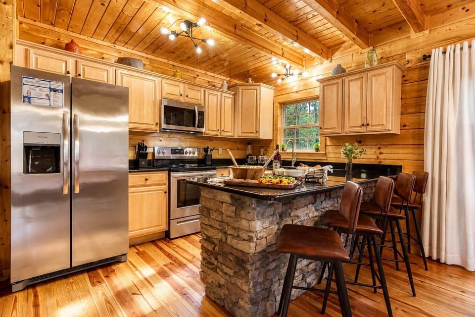 Host and cook in style with bar seating for four, sleek black granite counters, and stainless appliances in this gourmet kitchen.