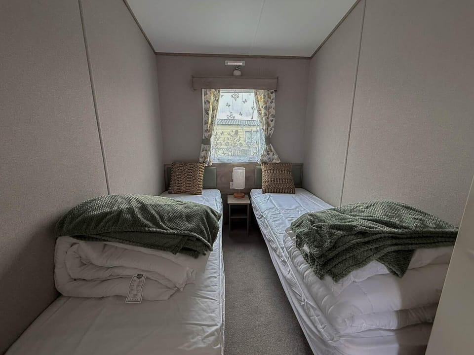 Cozy twin bedroom with soft natural light and peaceful ambiance