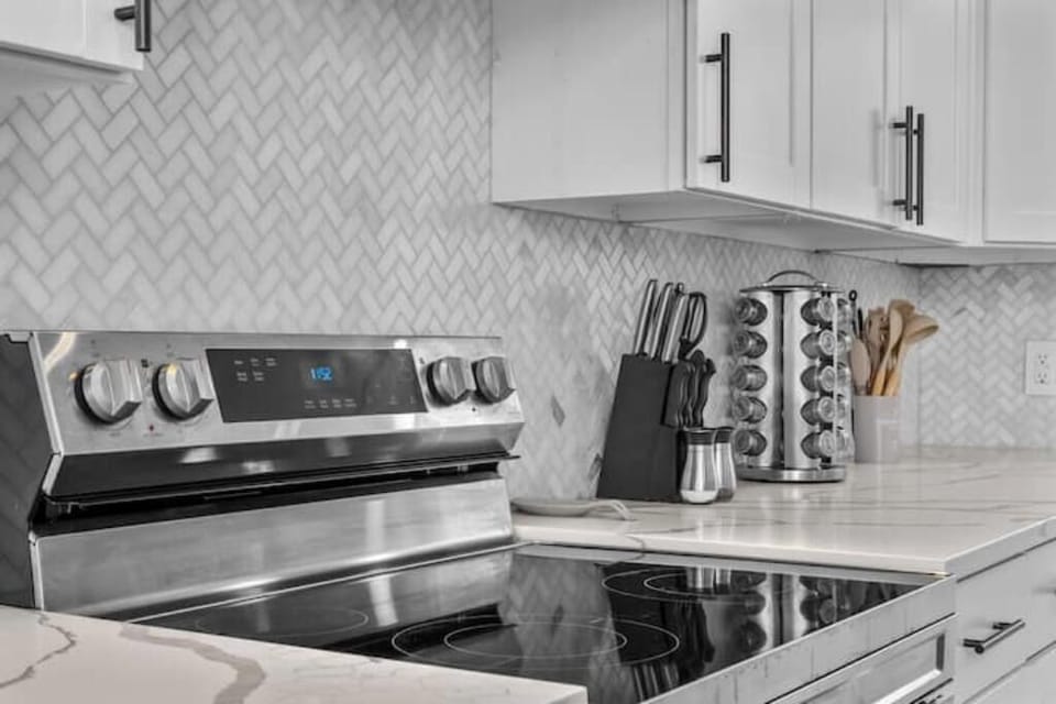 Fully equipped kitchen with stainless steel appliances and ample prep space.