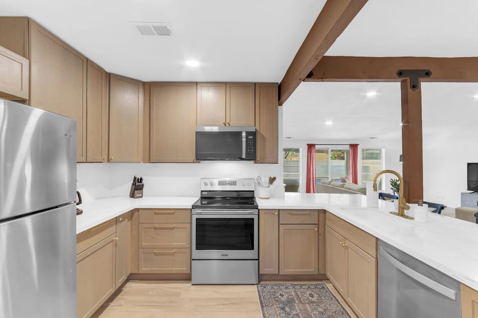 This modern kitchen features stainless steel appliances, sleek quartz countertops, and an open layout perfect for cooking and entertaining