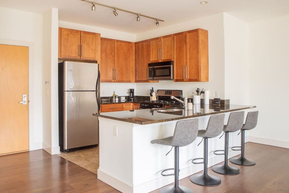 The full modern kitchen features stainless steel appliances and bar stool seating, making it easy to whip up morning breakfast or entertain your group