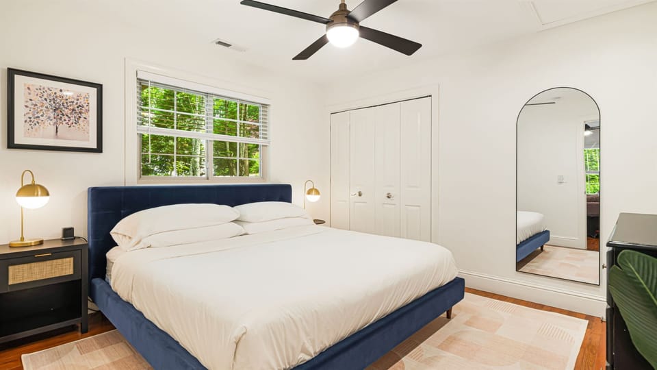 Awaken naturally as sunlight filters through the trees. The Helix hybrid king-sized mattress rests low, the ceiling fan gently turning, and a full-sized closet for easy unpacking.