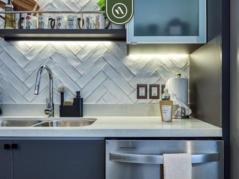 Fully equipped chef's kitchen with sleek countertops, gas stove, stainless appliances, and bar seating, ideal for cooking or casual dining.