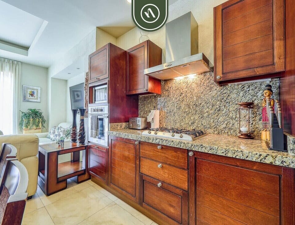 Prepare meals with ease in this well-appointed kitchen, featuring beautiful cherry wood cabinetry, spacious granite countertops, and modern built-in appliances.
