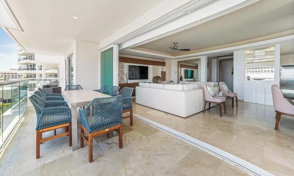 Expansive perspective showing the woven terrace dining set connecting directly into the bright open-concept living area.