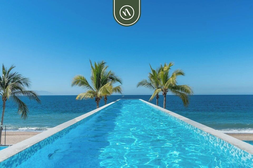 infinity pool overlooking the Pacific Ocean with uninterrupted views, palm-lined edges, and a serene resort atmosphere perfect for sunsets and relaxing just steps from the beach.