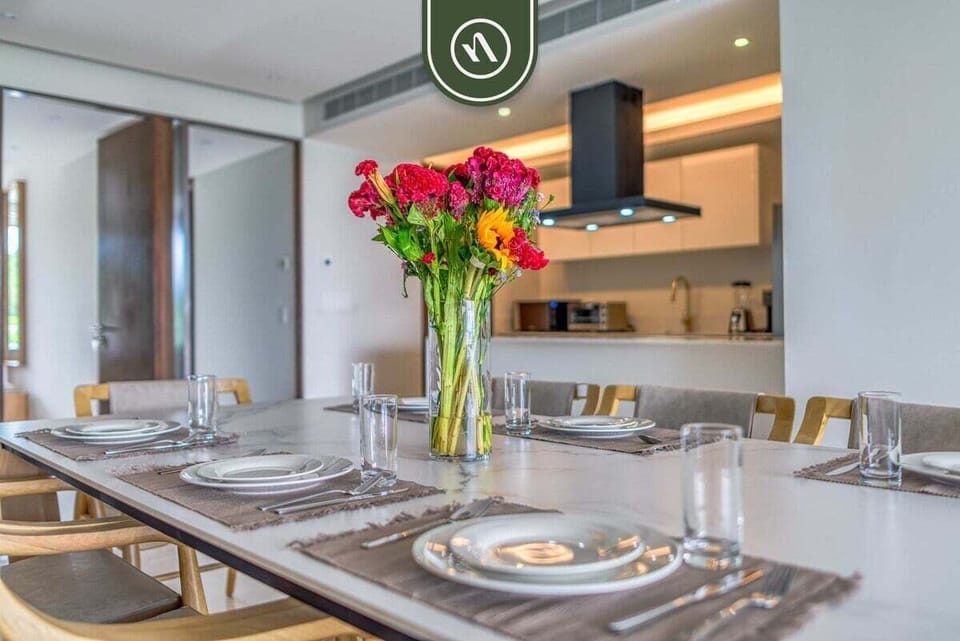 Bright dining area seamlessly connected to the modern kitchen, perfect for shared meals and entertaining. Stylish table setting and open layout create a welcoming space for gatherings.