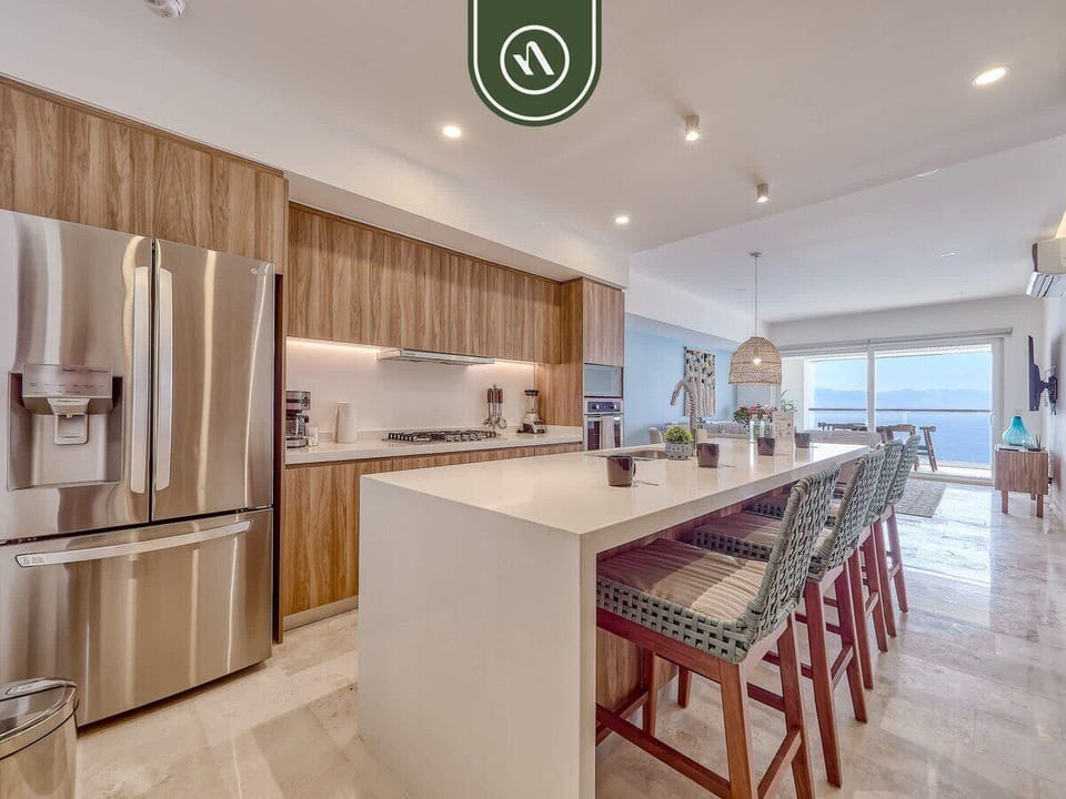 Fully equipped kitchen featuring stainless appliances, a large island with bar seating, and plenty of space for cooking and entertaining during your Puerto Vallarta stay.