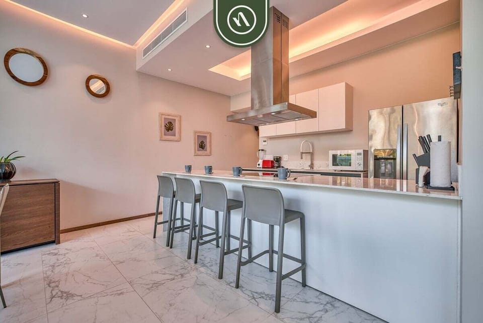 Cook and entertain with ease in the fully equipped kitchen featuring modern appliances, generous counter space, and bar seating.