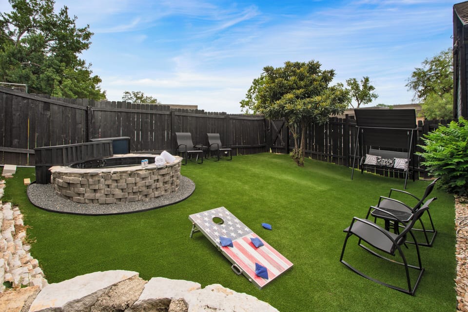 Shared backyard with cornhole, outdoor dining table, ample seating, and a custom pool.