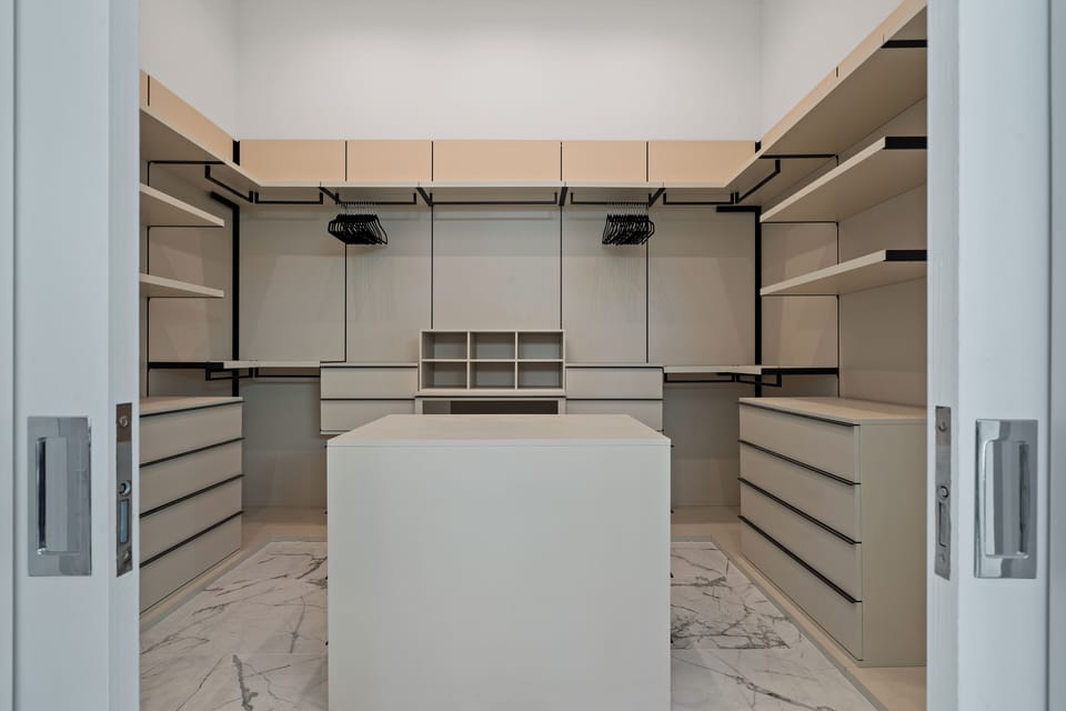 Expansive walk-in closet with custom Italian built-ins.