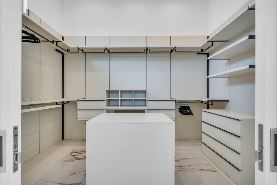 Expansive walk-in closet with custom Italian built-ins.