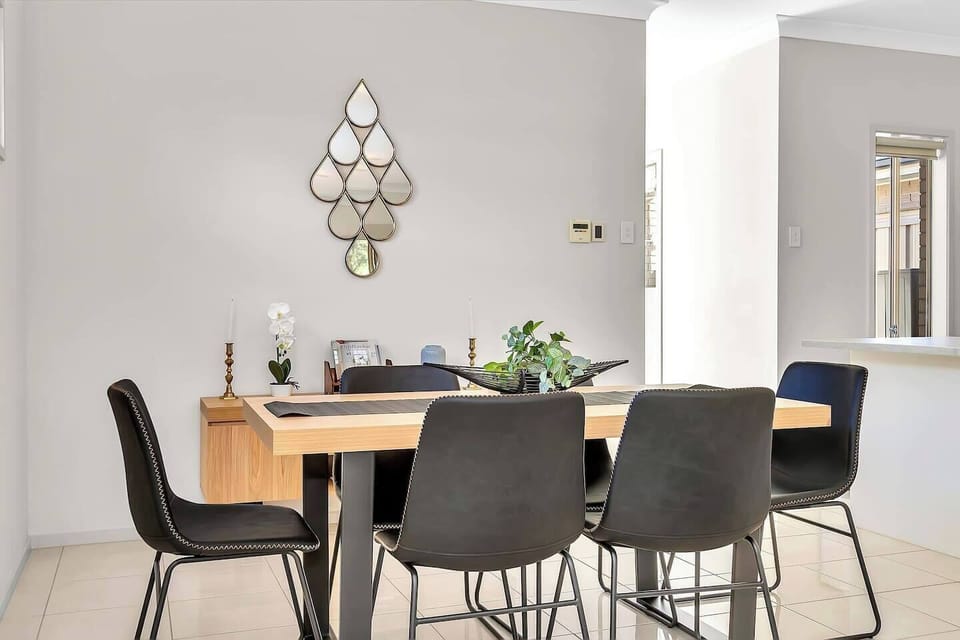 Gather for meals at the stylish indoor dining table, positioned to enjoy leafy glimpses while sharing stories over home-cooked meals or local takeaway.