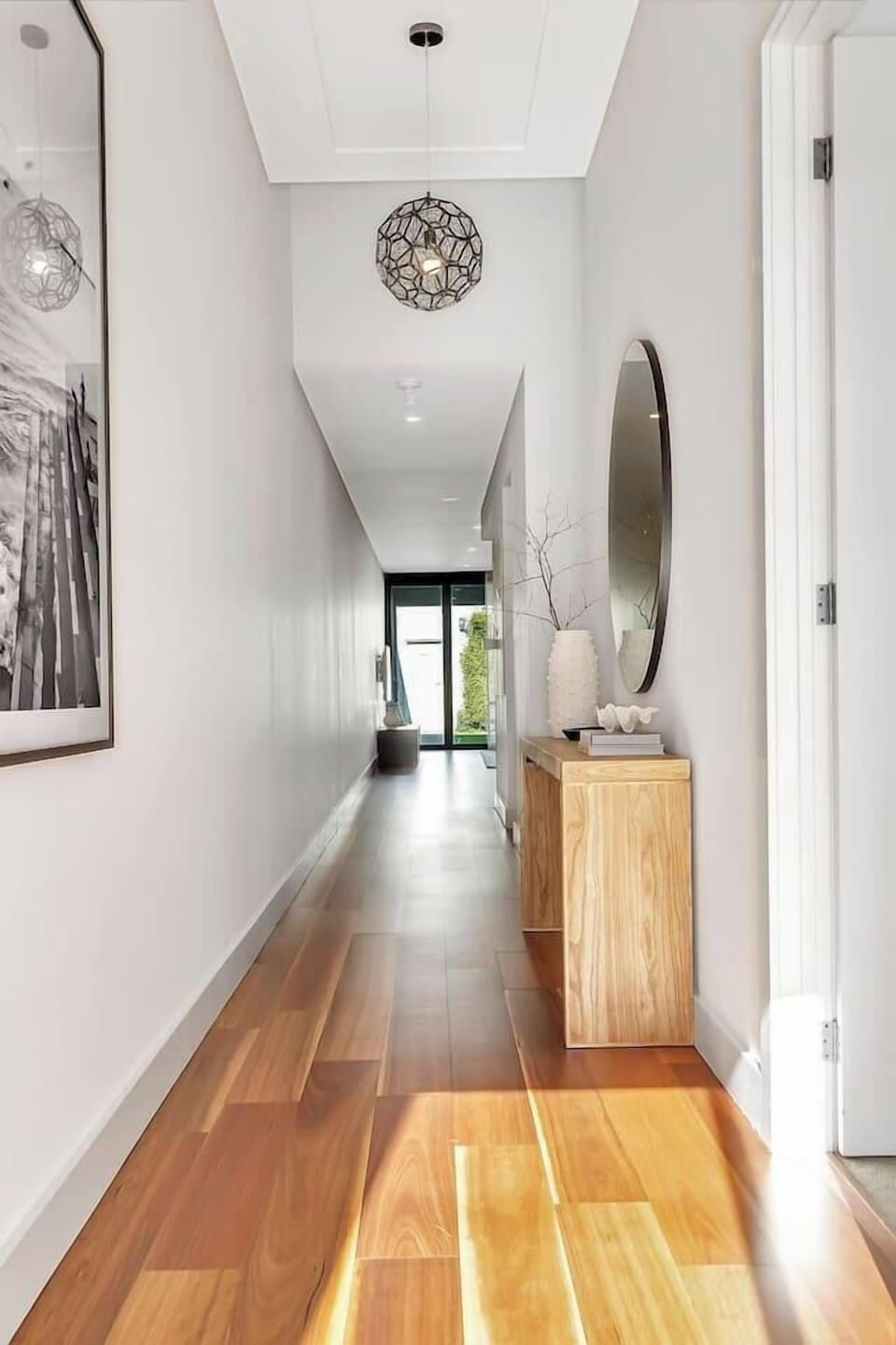 Step inside to the bright, welcoming hallway with warm timber floors and thoughtful touches that guide you into the heart of the home.