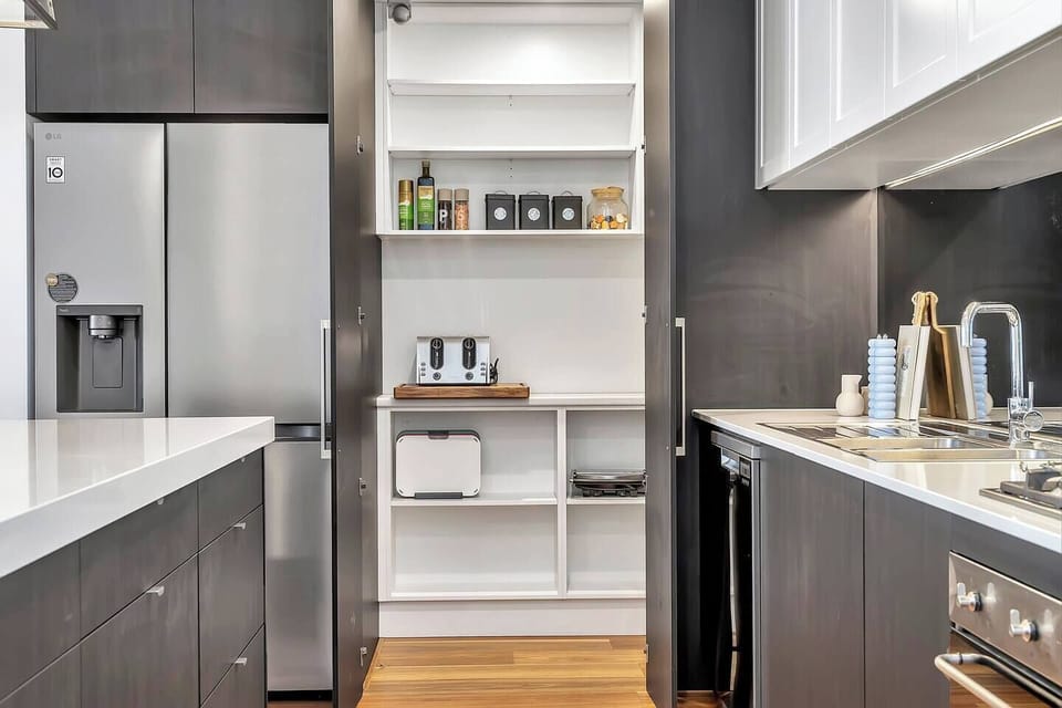 Tucked behind cabinetry, the hidden pantry keeps essentials organised and your bench clutter-free, stocked with cooking basics and convenient appliances.